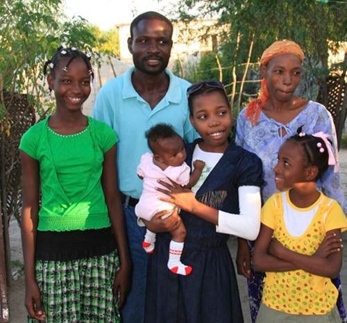 Hermmy (middle, holding baby) with her family in Haiti.