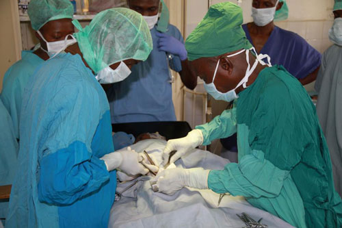Dr. Martin Salia performing hernia surgery on a young boy.