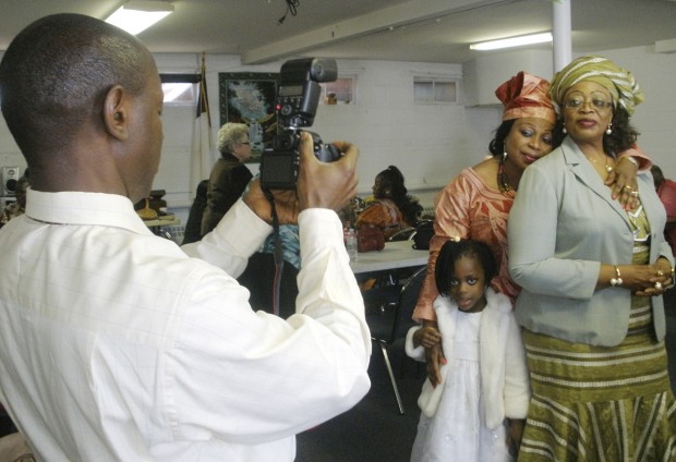 Abdul Kamara takes a picture of, from left, 5-year-old Fatmata Somtir with Rosaline Cook and Mamie Sowa during a luncheon following a revival service at Brooklyn Park United Brethren in Christ Church on Sunday. All four are members of Mount Zion United African Church in Philadelphia. The Brooklyn Park church held the revival as a way to celebrate its growing international community and its partnership with Mount Zion. Photo by Jennifer Donatelli.