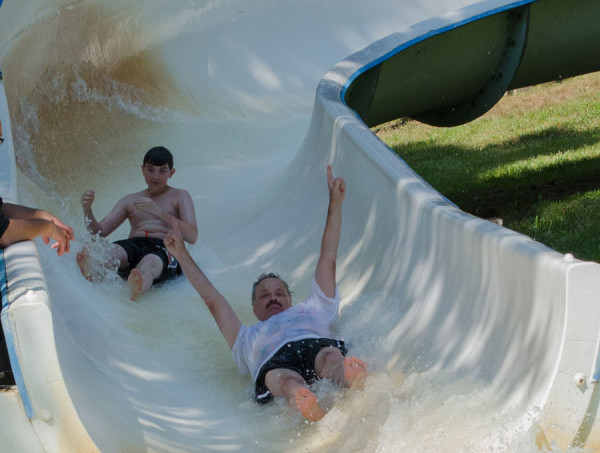 Pastor Les Smith winning, once again, on the water slide.