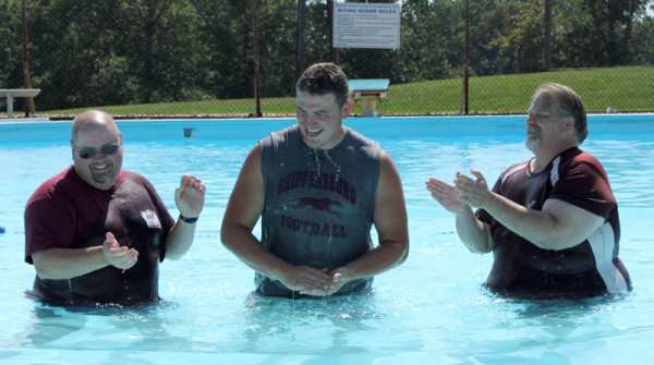 Pastor Jim Bolich (left) conducts one of the day's five baptisms.