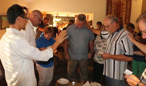 Staff and spouses praying Numbers 6:24-26 over Phil and Sandy Whipple.