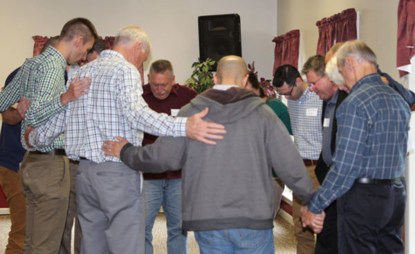 Attendees praying to conclude the meeting.